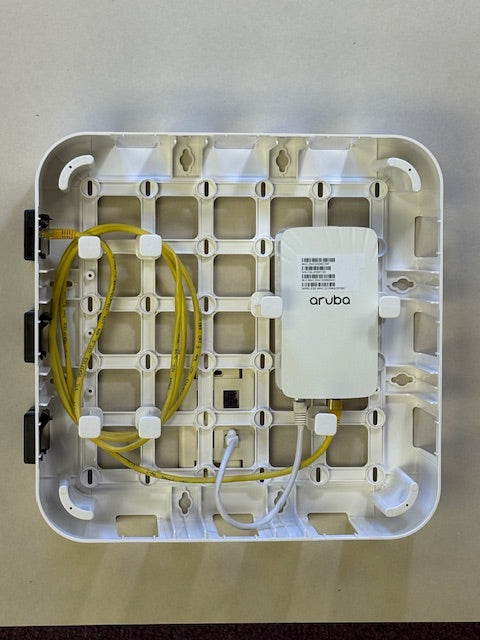 Inside Wire Wonder with an Aruba wireless access point and network cables organized on the pegs