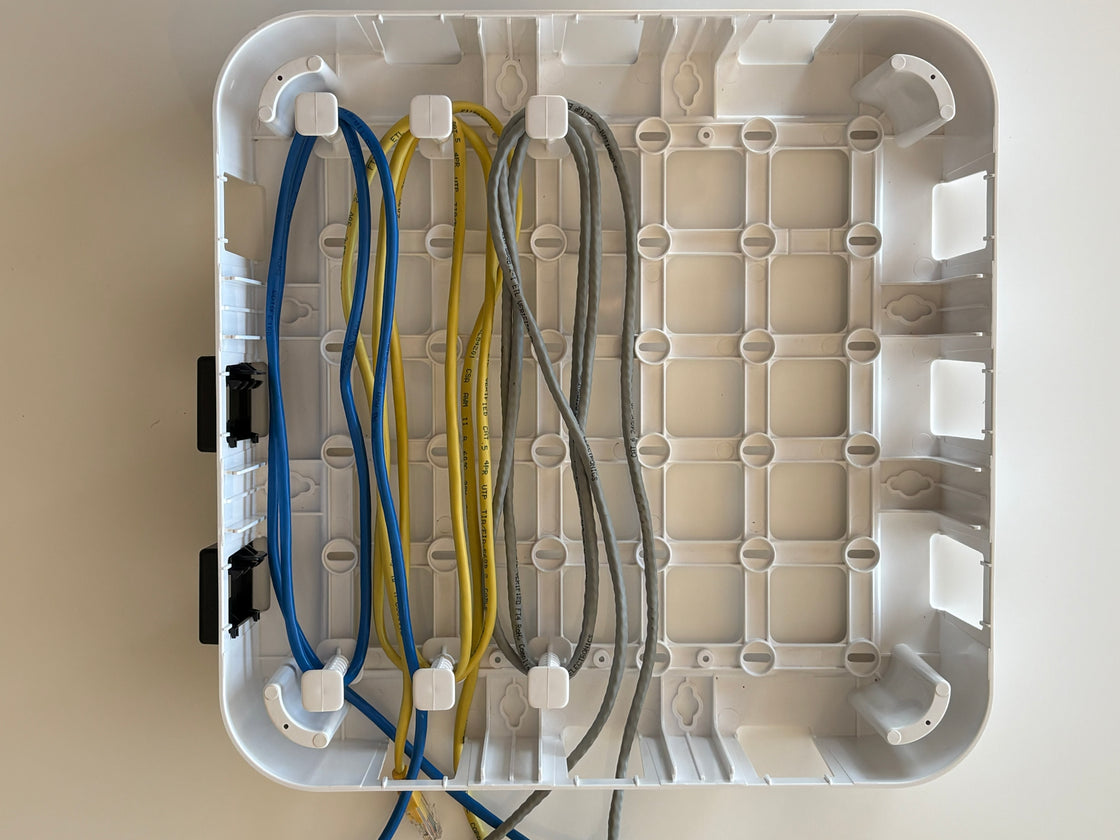 Wire Wonder cable management box, with 3 cables routed with 6 pegs